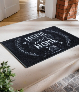 melns durvju paklājiņš ar uzrakstiem